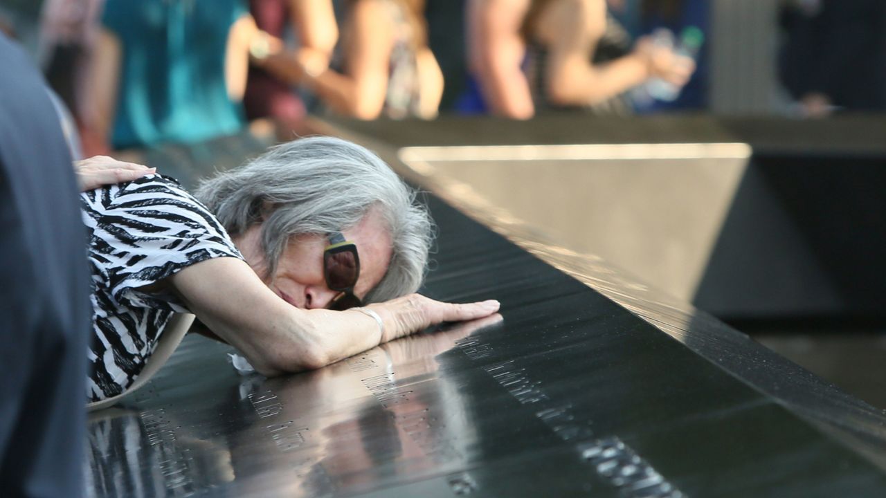 Mija Quigley of Princeton Junction, New Jersey, embraces the name of son Patrick Quigley at the 9/11 Memorial on September 11. He died aboard United Airlines Flight 175, which crashed into the World Trade Center on 9/11.