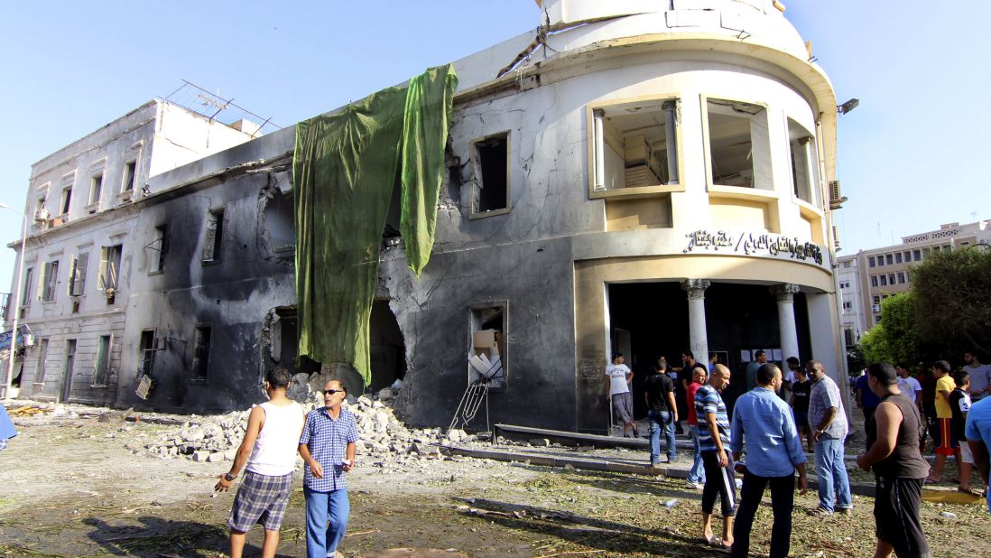 People gather to look at the site of a car bombing in Benghazi, Libya, on Wednesday, September 11. The bomb went off outside a Foreign Ministry building, state media said, one year after an assault on the U.S. Consulate there that killed four Americans, including Ambassador Christopher Stevens.