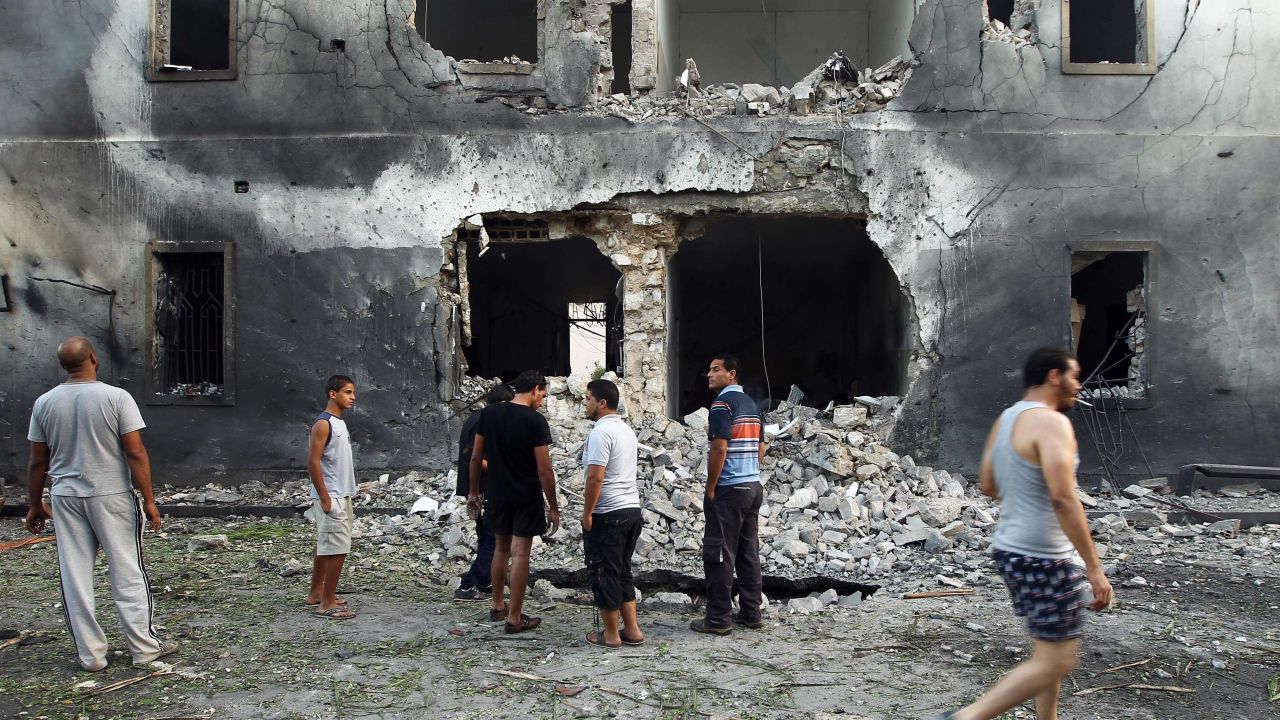 People gather outside the building that was hit by a car bomb.