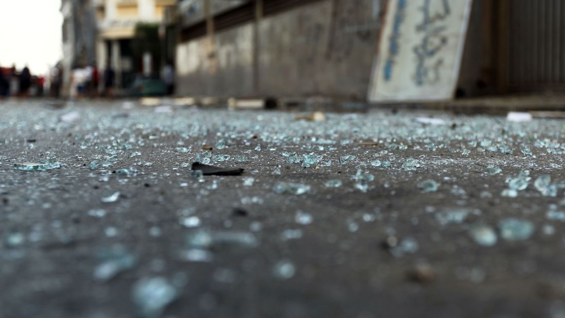 Pieces of glass lay on the ground outside the building.