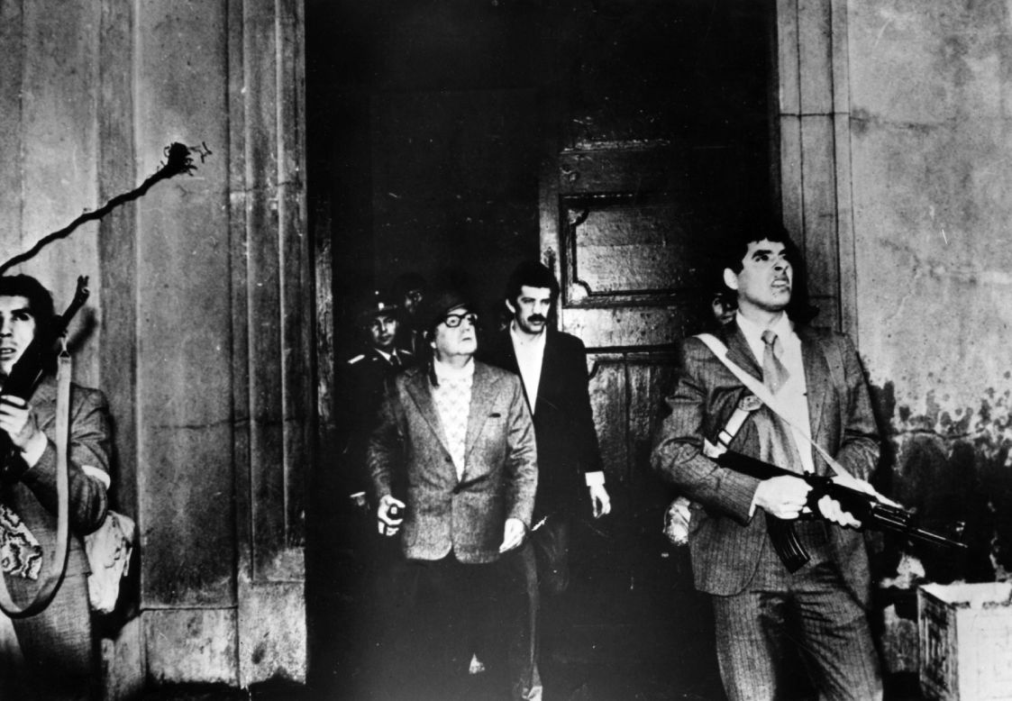 Armed guards watch out for attackers as Allende leaves the Moneda Presidential Palace during the military coup in which he was overthrown and killed in the palace on September 11, 1973. This is said to be the last photo of the president.