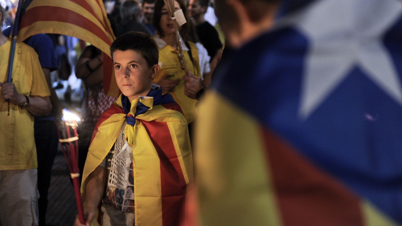 People wrapped in 'Estelada' Catalan independence flags march during a rally for independence in Barcelona on September 10.