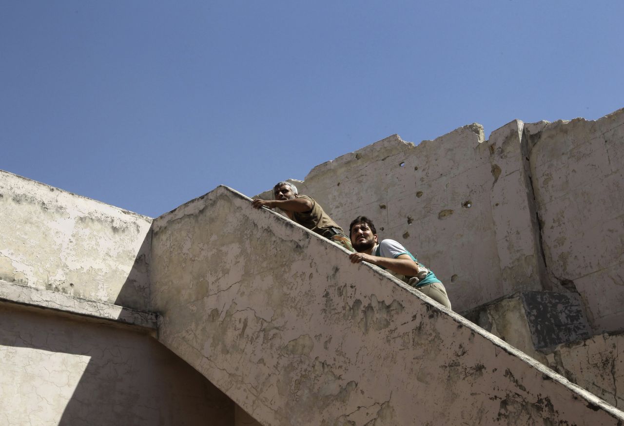 Free Syrian Army fighters climb a flight of stairs to take positions near the Hanano barracks on September 11.