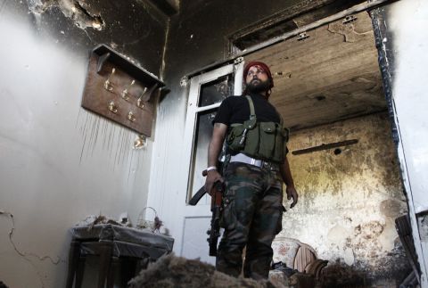 A Free Syrian Army fighter stands guard inside a damaged house in Aleppo's Qastal al-Harami neighborhood on September 11. 