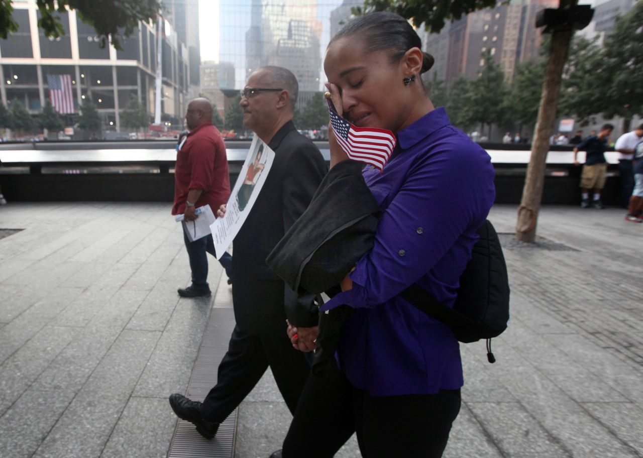 Hector Garcia, center, of Brooklyn, and his daughter Tania attend ceremonies in New York on September 11. Garcia is carrying a photograph of his daughter Marilyn, Tania's sister, who died in the attacks on the World Trade Center.
