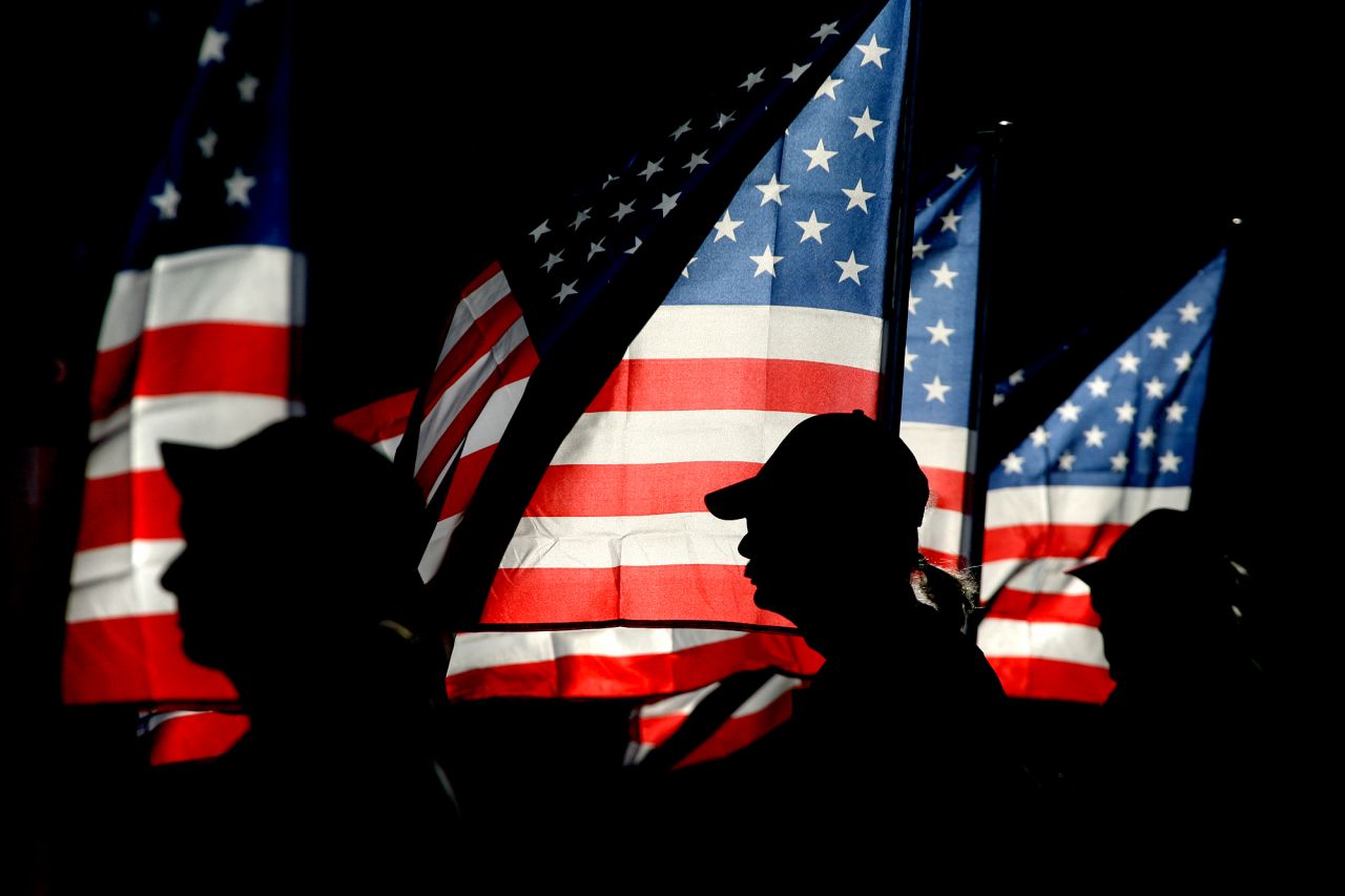 Patriot Guard rider and U.S. Navy veteran Ron Connally, center, of Oak Harbor, Washington, holds a flag during a ceremony in Bremerton on September 11.