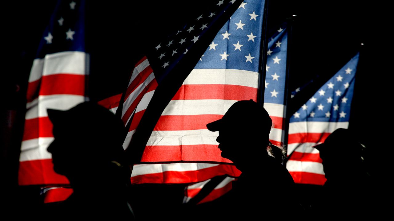 Patriot Guard rider and US Navy veteran Ron Connally, center, of Oak Harbor, holds a flag during a 9/11 ceremony in Bremerton, Washington, on September 11, 2012.