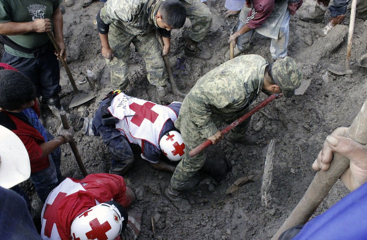 Soldiers and Red Cross members look for victims of a landslide caused by heavy rains in Coscomatepec, Mexico, on Tuesday, September 10. At least nine people were killed, including four children, in the Mexican state of Veracruz by flooding and landslides caused by heavy rains, authorities said.