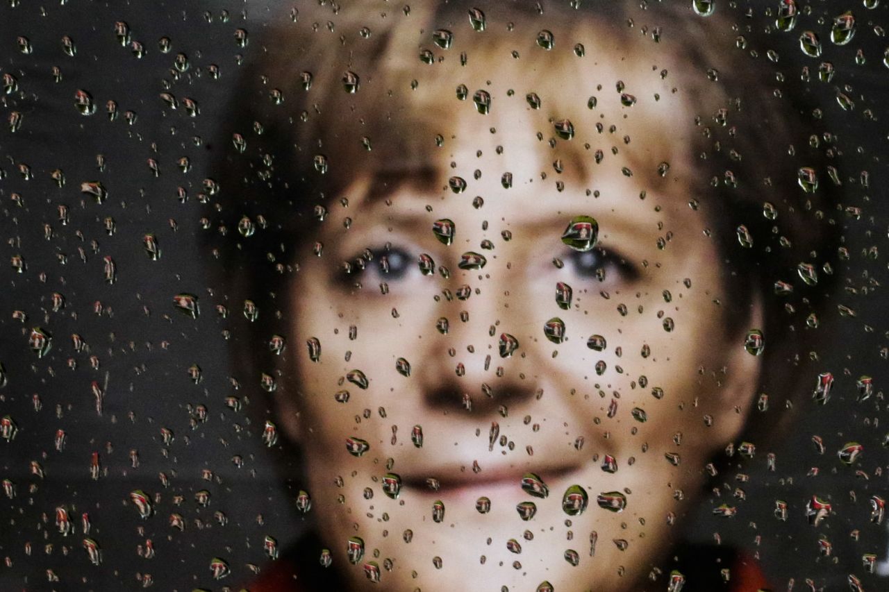 An election campaign poster of German Chancellor Angela Merkel is photographed through a rain-flecked car window in Berlin on September 9.