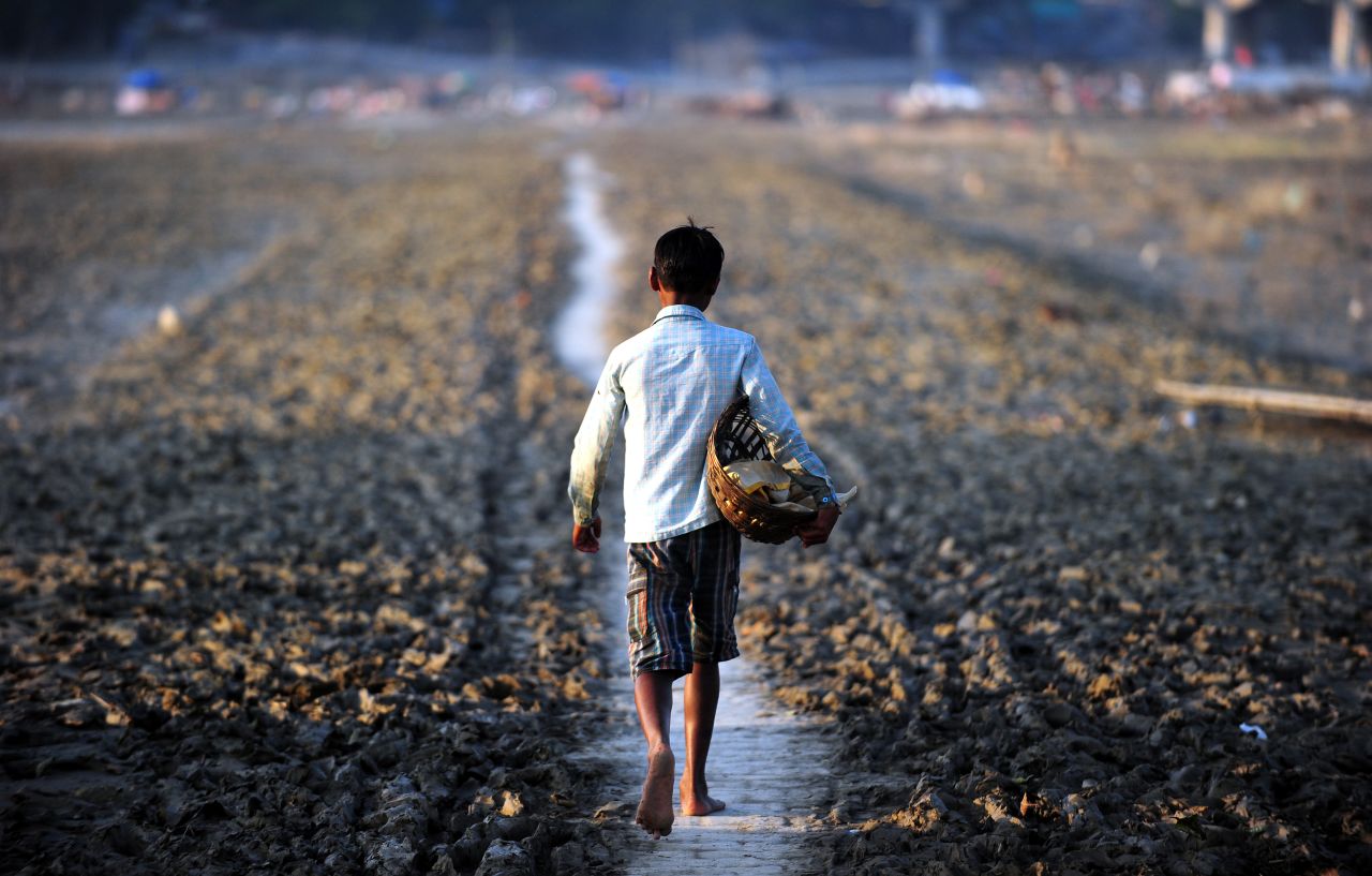 A flower seller walks through a marshland after the flood waters receded in Allahabad, India, on September 9.