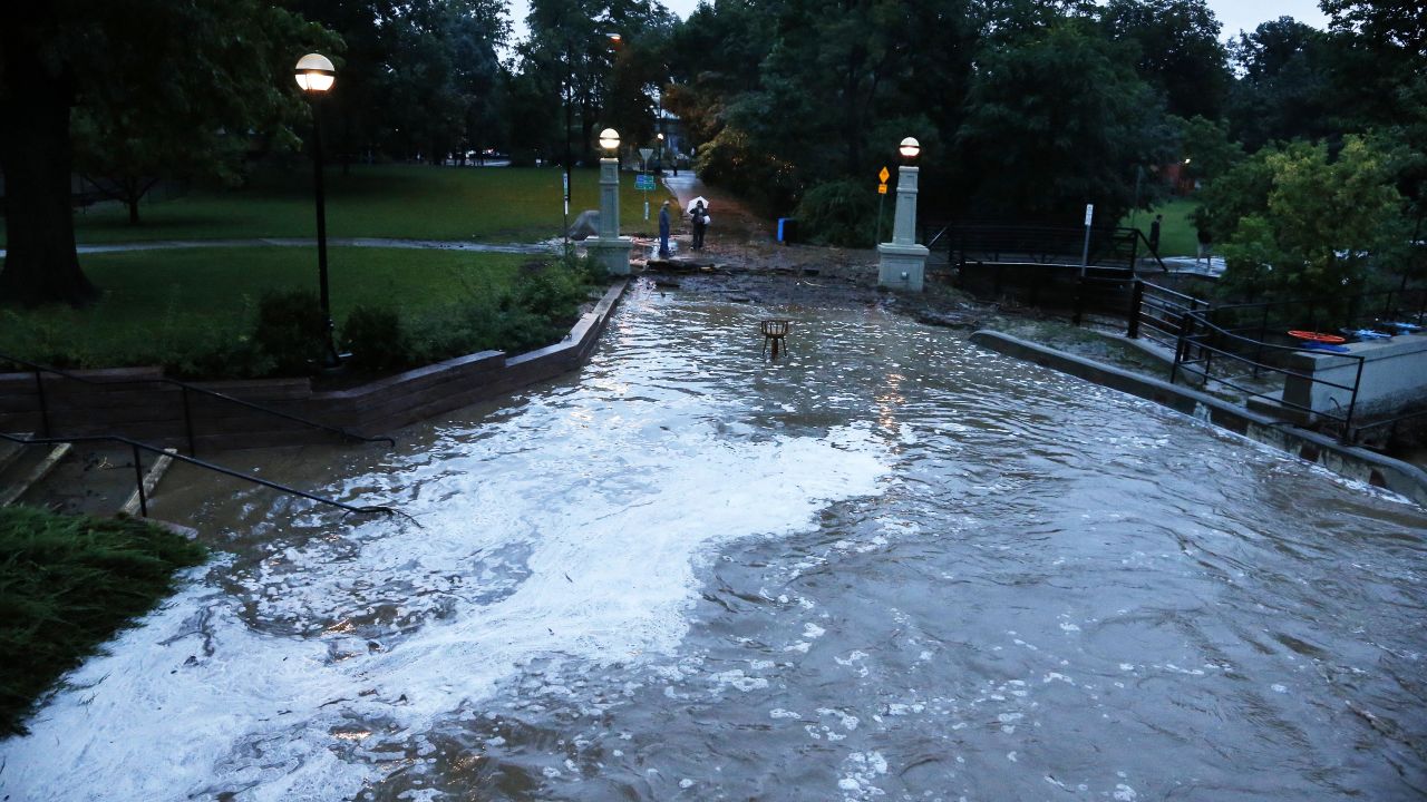 Flash flood waters rush over a walking path in downtown Boulder on September 12.