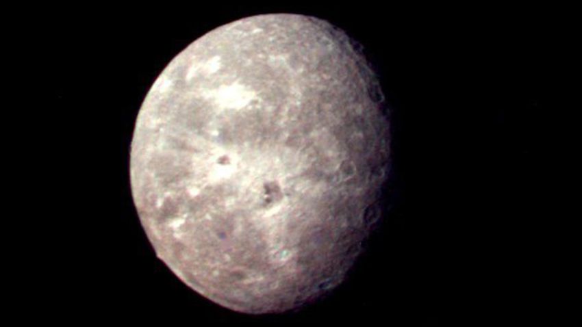 Oberon, Uranus' outermost moon, shows several impact craters on the moon's icy surface.