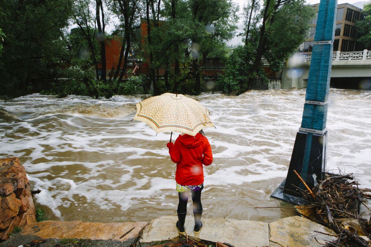 A woman looks at the flooded Boulder Creek on September 12.