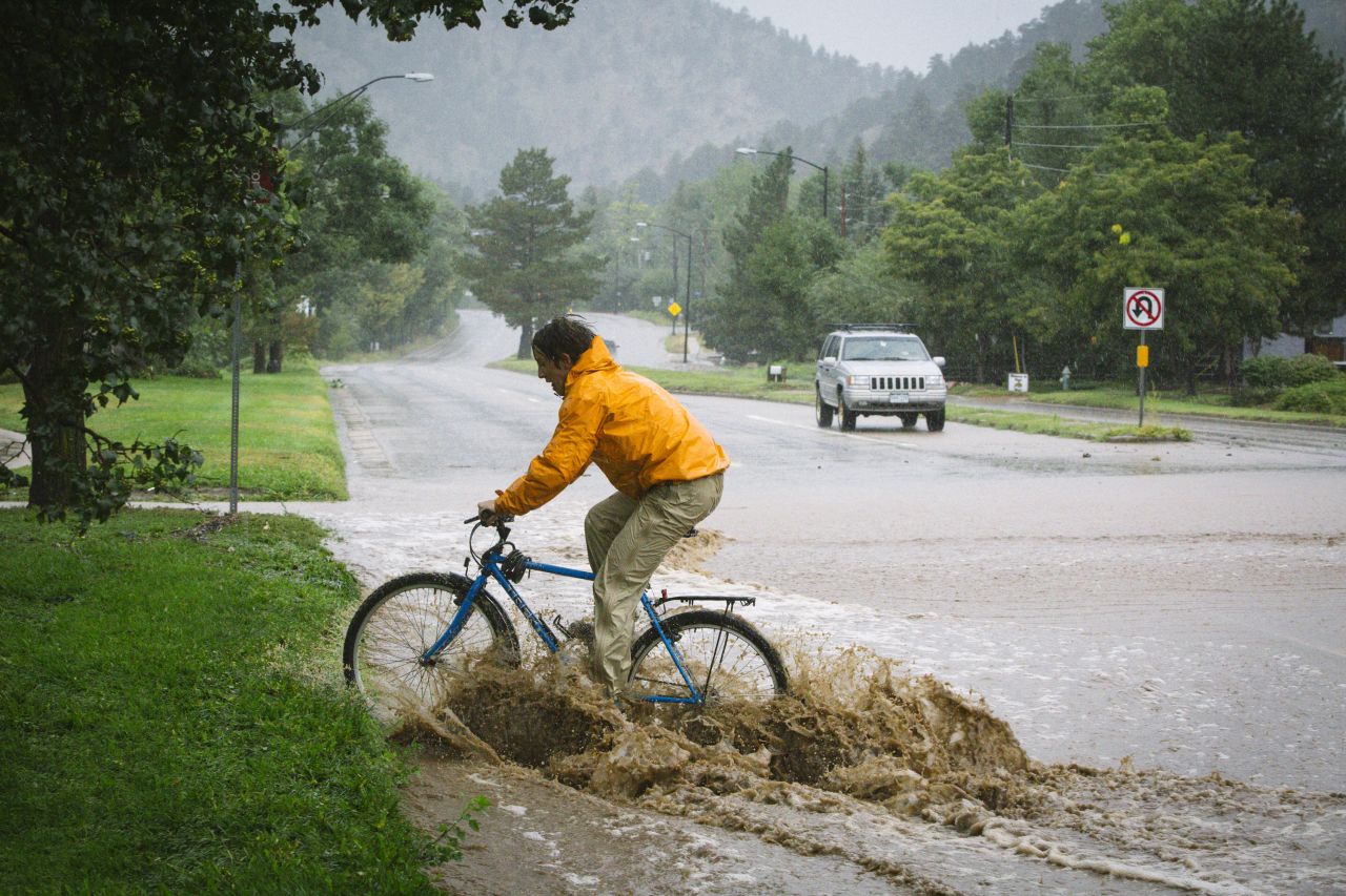 Joey Schusler rides through flooded Canyon Boulevard in Boulder, on September 12.