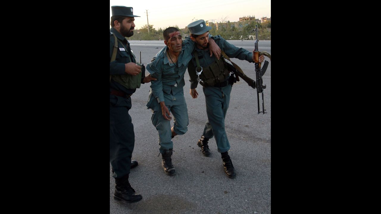 Afghan security officials help an injured colleague  on September 13.