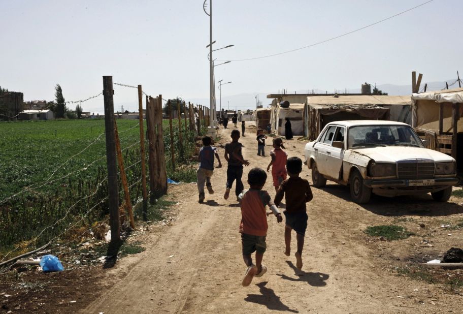 Syrian refugee children run near their tents at a temporary refugee camp near the Lebanese border in September 2013.