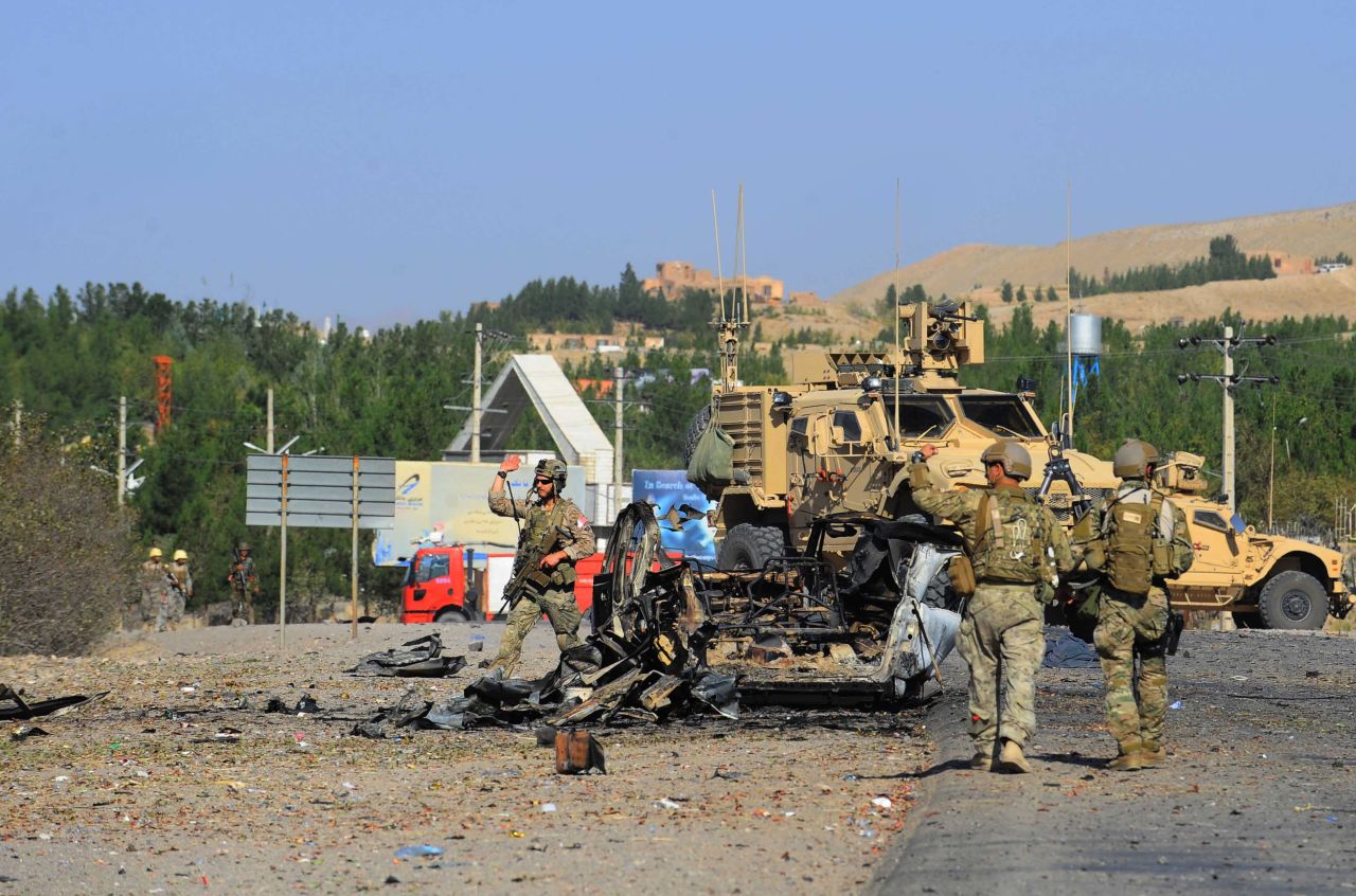 U.S. military forces observe the wreckage of a car bomb near the U.S. consulate in Herat, Afghanistan, on Friday, September 13. Seven heavily armed Taliban suicide attackers struck the consulate, setting off two car bombs and sparking a shootout with U.S. forces.  