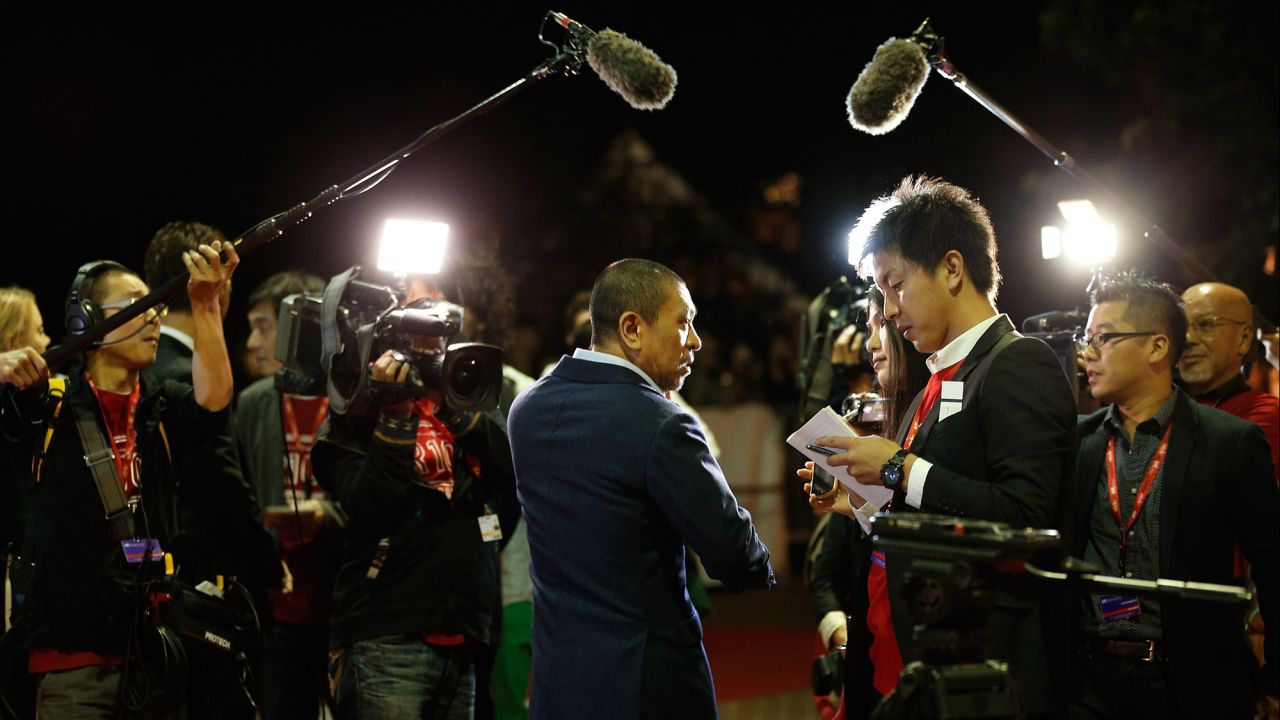 Director Hitoshi Matsumoto, center, faces reporters at the premiere of "R100" on September 12.