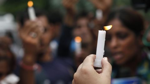 People hold candles outside the courthouse in New Delhi.
