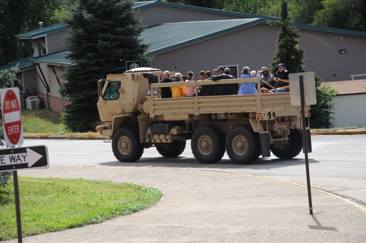 Residents ride in the back of an LMTV while being evacuated to Longmont on September 13.