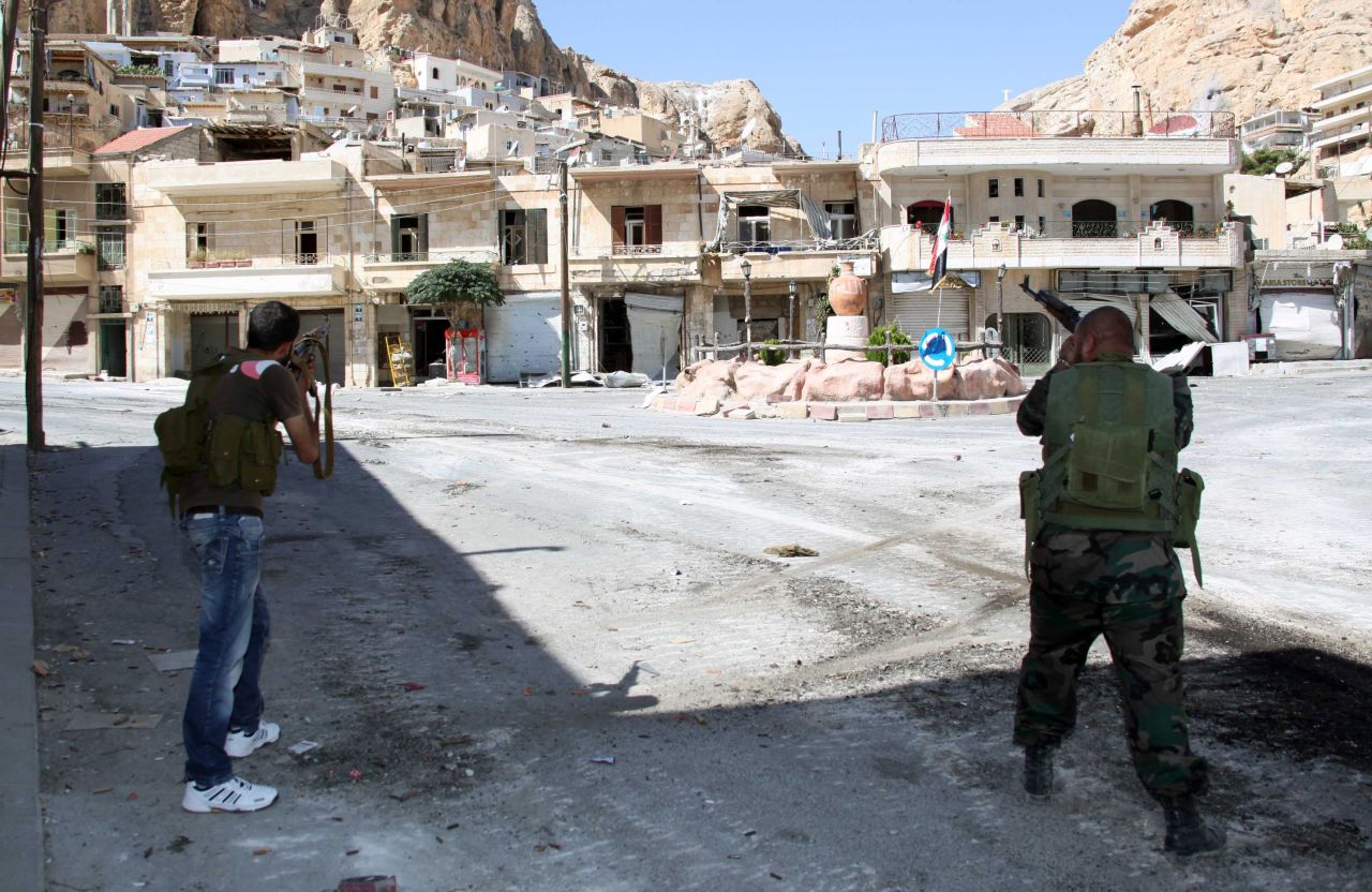 Syrian soldiers take aim at rebel fighters positioned in the mountains of the Christian town of Maalula on September 13.