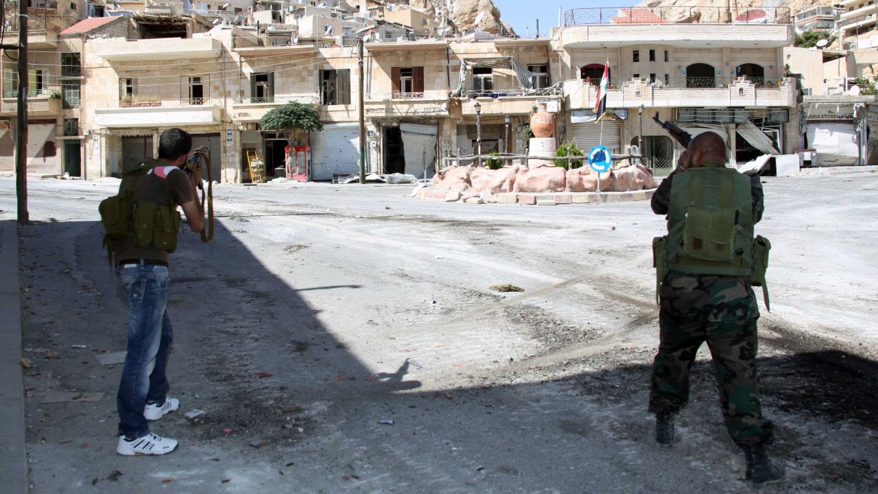 Syrian soldiers take aim at rebel fighters positioned in the mountains of the Christian town of Maalula on September 13, 2013. Syria's opposition National Coalition said it was "deeply sceptical" about the government's decision to join a chemical weapons ban and urged a tough UN resolution to enforce the measure. AFP PHOTO/STR        (Photo credit should read -/AFP/Getty Images)