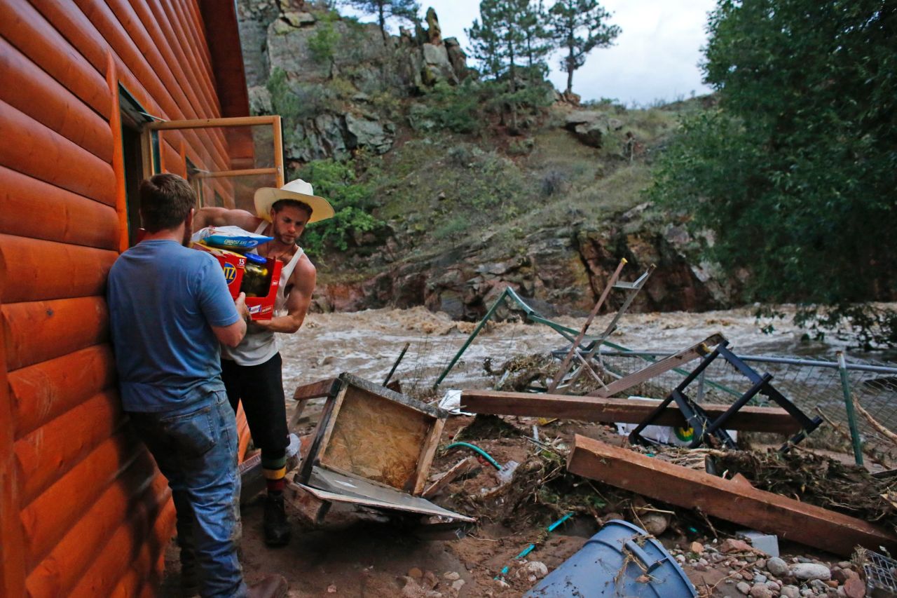 Chris Rodes helps Fred Rob salvage a friend's belongings after floods left homes and infrastructure in shambles in Lyons, Colorado, on September 13.