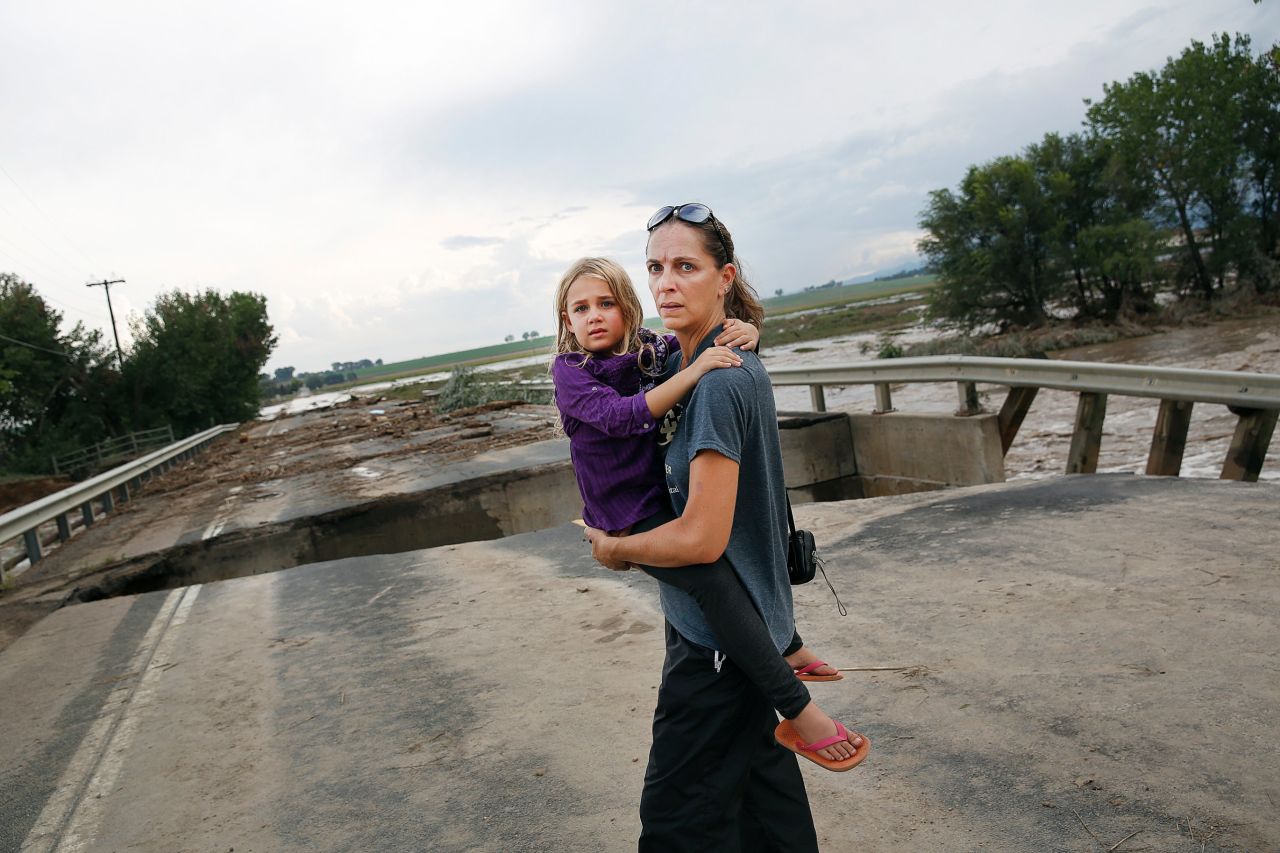 Samantha Kinzig of Longmont, Colorado, and her 5-year-old daughter, Isabel, take a closer look at the damaged bridge on Weld County Road 1 on September 13.