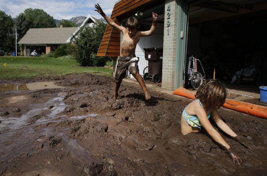 Eli and Noe Sura play in the mud around their Boulder, Colorado, home on September 14. 