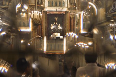 Romanian Jews, seen through a glass door, attend a religious service ahead of Yom Kippur at the Great Synagogue in Bucharest, Romania.