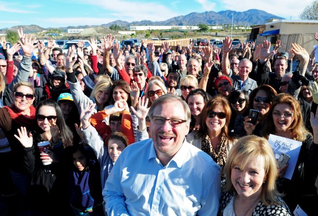 Warren and his wife, Kay, pose with a crowd during the grand opening of the P.E.A.C.E Center at Saddleback Church on December 12, 2011. The center will provide services for low-income families including medical help, counseling, tutoring and food.