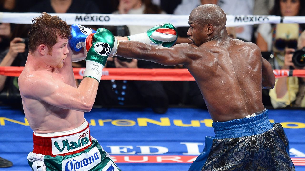 Floyd Mayweather Jr., right, throws a left at Canelo Alvarez during their WBC/WBA 154-pound title fight at the MGM Grand Garden Arena on September 14, 2013 in Las Vegas, Nevada. 
