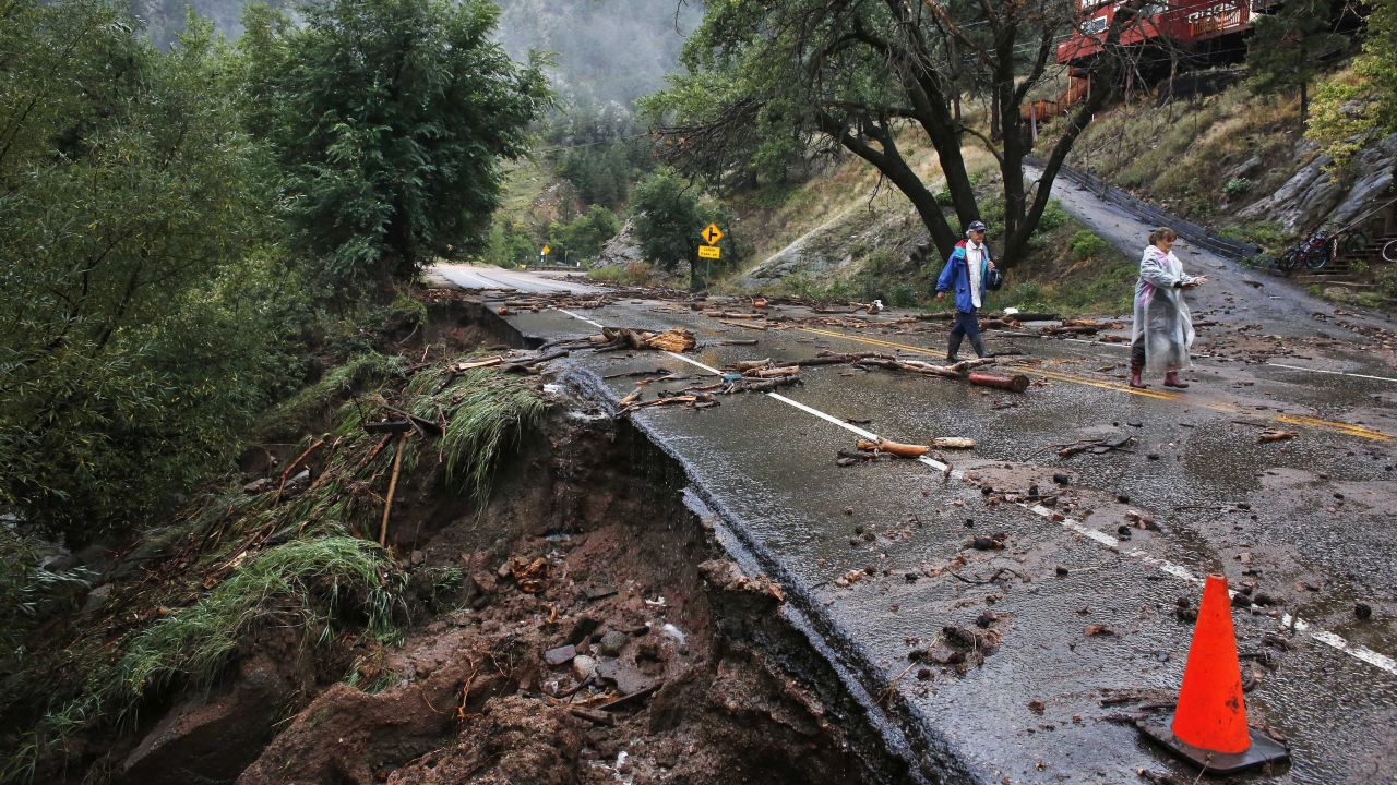 Siblings Patrick Tinsley and Mary Kerns walk to Boulder, Colorado, on Friday, September 13, from their mountain community, Magnolia, at the base of Boulder Canyon, where road access is shut off by debris from days of record rain and flooding.