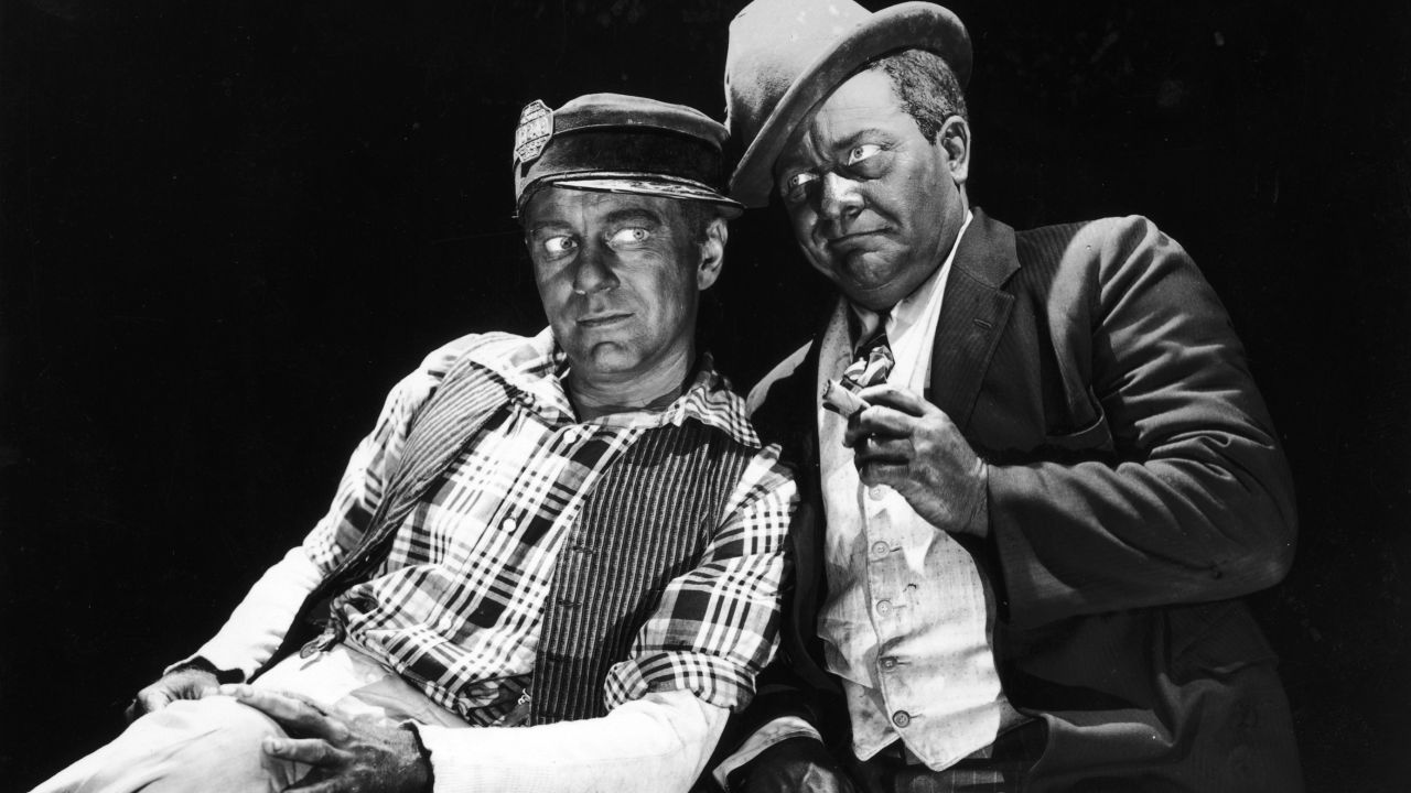 American actors and comedy partners Charles Correll (L) and Freeman Gosden lean against each other in blackface makeup in a 1949 promotional portrait.