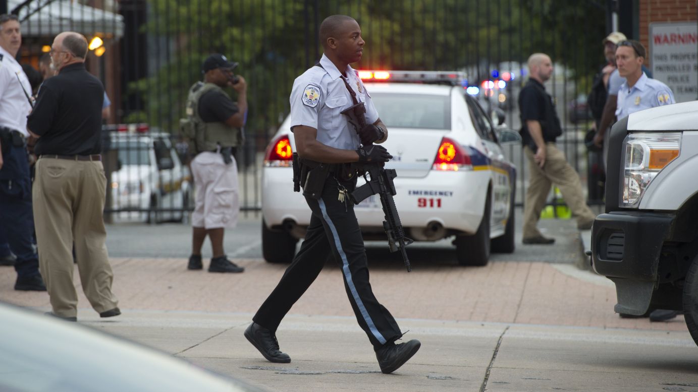 A police officer carries an automatic rifle at the Washington Navy Yard.