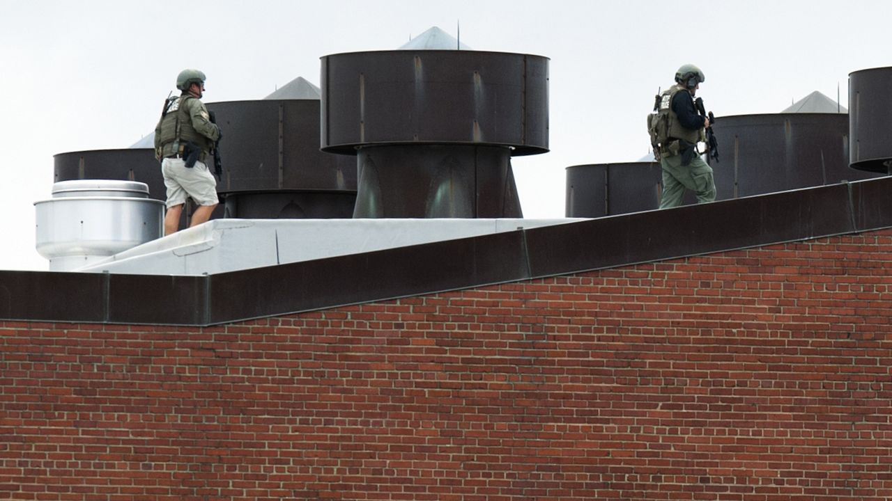 Police officers walk on a rooftop at the Washington Navy Yard.