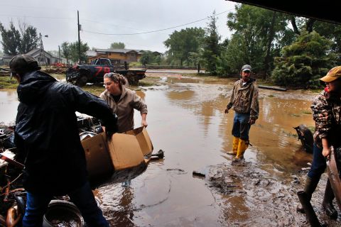 Local residents, from left, Levi Wolfe, Miranda Woodard, Tyler Sadar, and Genevieve Marquez help salvage and clean property after days of flooding in Hygeine, Colorado, on September 16.