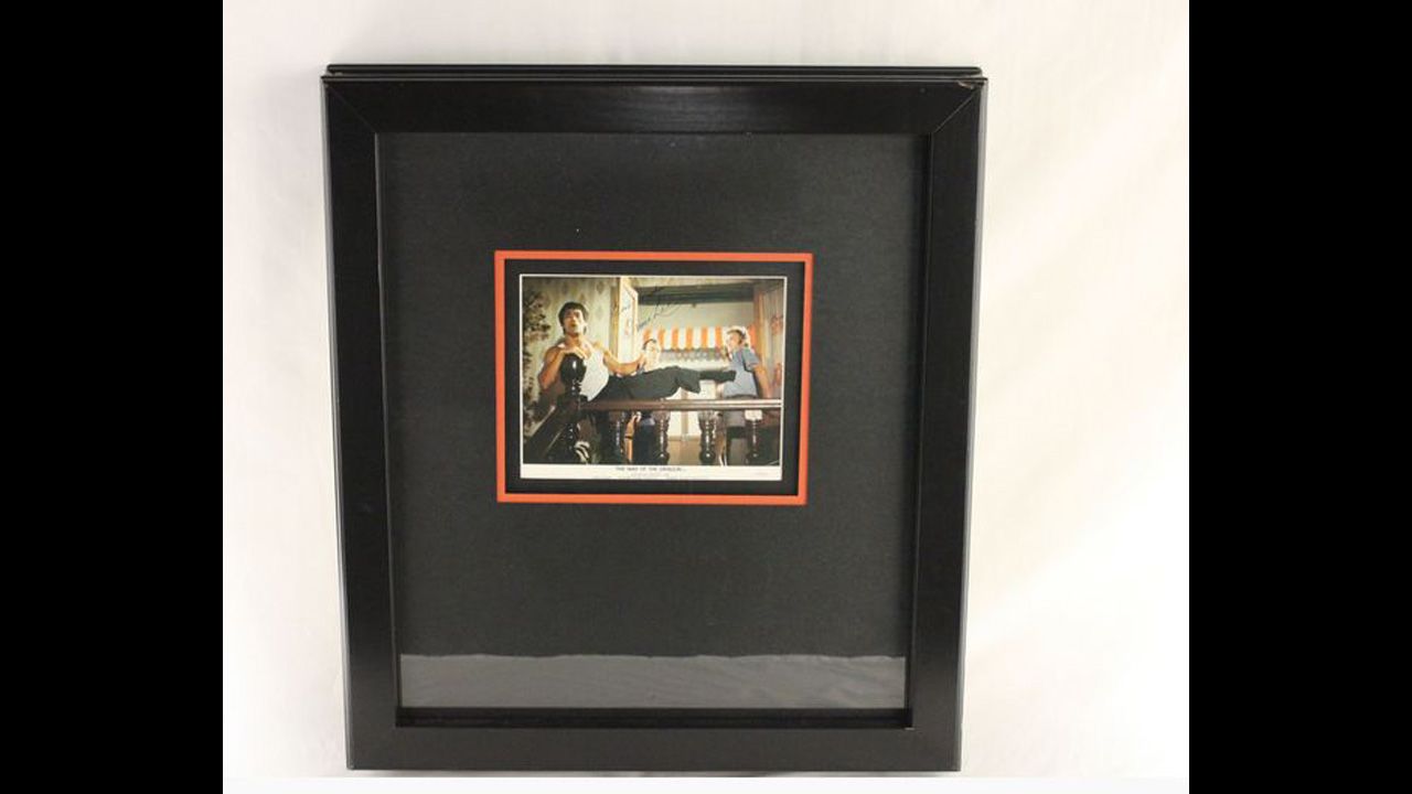 Double framed and matted 8-by-10-inch color photo from "The Way of the Dragon" movie, autographed "Best Wishes Bruce Lee." 