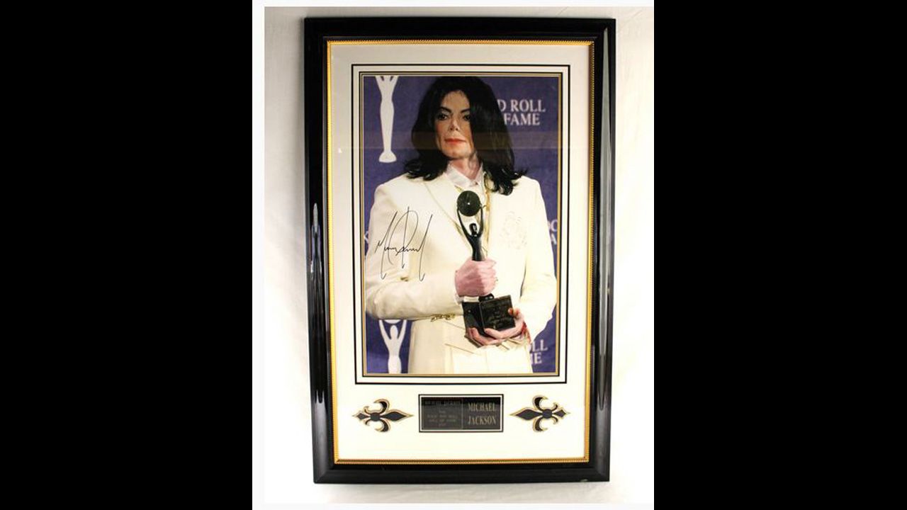 Framed and matted poster of Michael Jackson's induction into the Rock and Roll Hall of Fame, 2001, autographed "Michael Jackson."