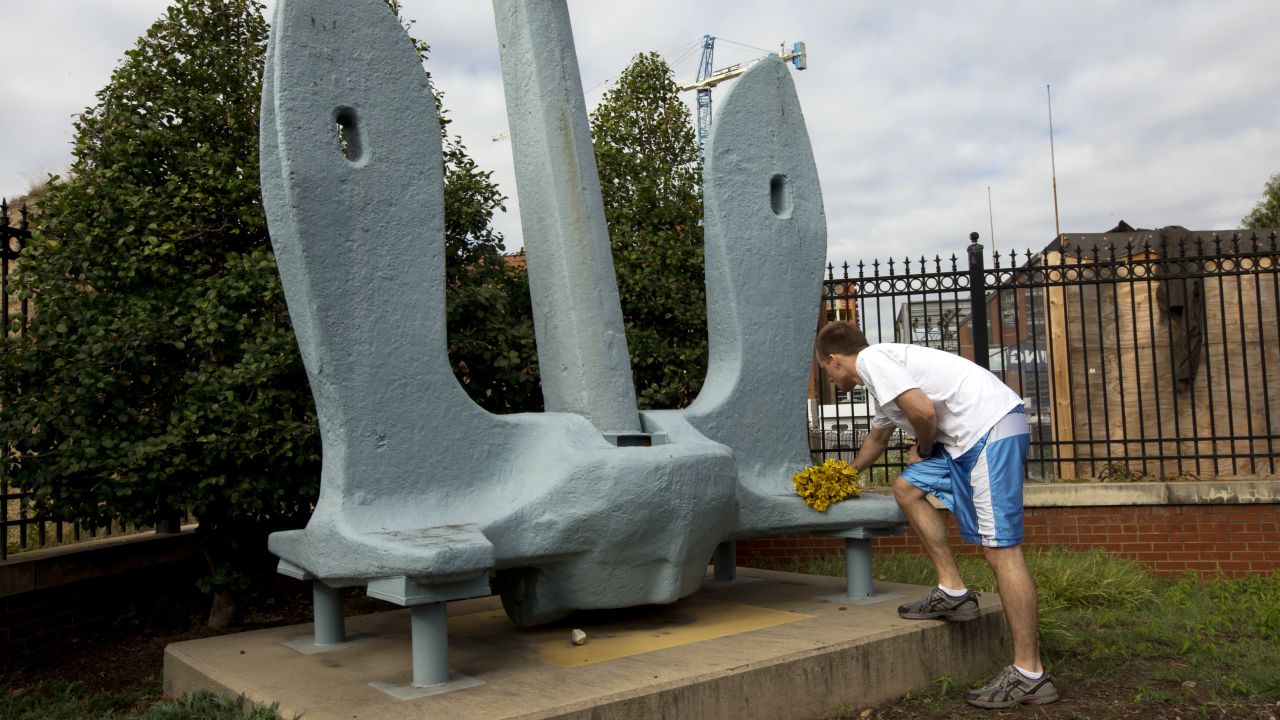 A man puts a bouquet at the anchor outside the Washington Navy Yard on Tuesday, September 17.