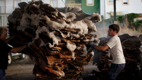 Jesus Rios Nogales, left, and Ezequiel Rodriguez take out a pile of cork planks from boiling at a factory on July 2 in Seville. 
