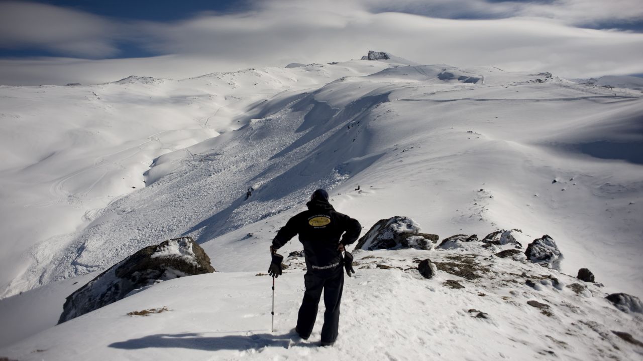 A man watches members of the Spanish Guardia Civil look for a climber buried by an avalanche in San Juan Canyon on February 21, 2011, in Granada. 