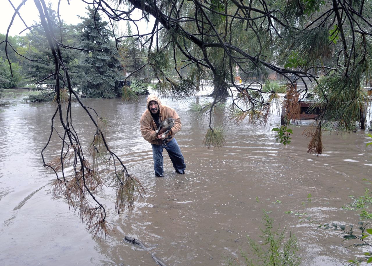Johnny C. Montoya helps rescue a cat from an area flooded by the Gallinas River in Las Vegas on September 13.