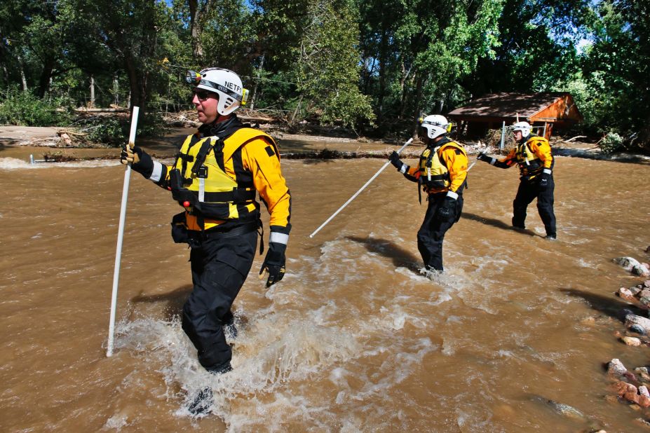 Members of the FEMA Urban Search and Rescue Nebraska Task Force 1 use probes to test for water depth while crossing floodwaters looking for missing people near Longmont, Colorado, on September 17. Stranded flood victims are being rescued by military helicopters and vehicles.
