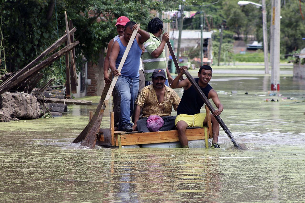 Con una balsa improvisada residentes cruzan una calle inundada en Chilpancingo