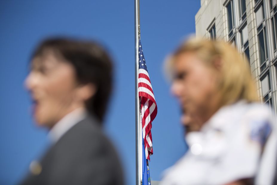 A flag flies at half-staff behind Valerie Parlave of the FBI and Washington Police Chief Cathy Lanier during a press conference on September 17 outside the FBI's field office in Washington.