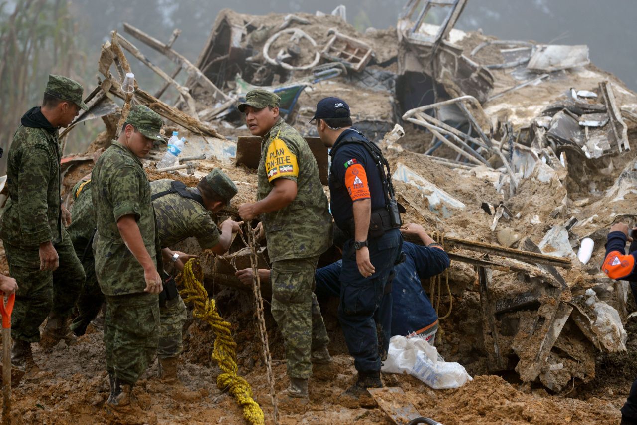 Soldados y policías mexicanos buscan víctimas tras un deslizamiento causado por las fuertes lluvias en la comunidad de Xaltepec, estado de Veracruz.