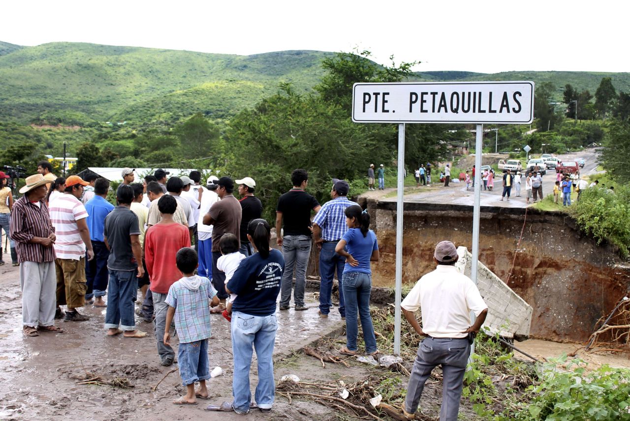 Los residentes miran un puente arrastrado por las fuertes lluvias en  el estado de Guerrero.