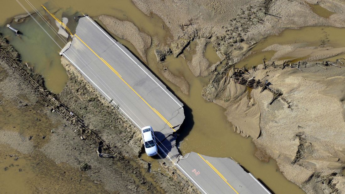 An abandoned car sits on a destroyed road along the South Platte River near Greeley, Colorado, on Tuesday, September 17.