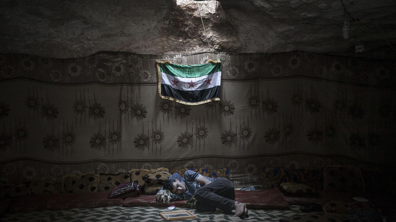 A Free Syrian Army fighter rests inside a cave at a rebel camp in Idlib province on Tuesday, September 17. 